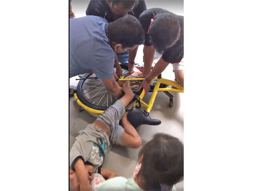 男童的左腿卡在鐵條之間，公眾紛紛上前援救。（受訪者提供）
