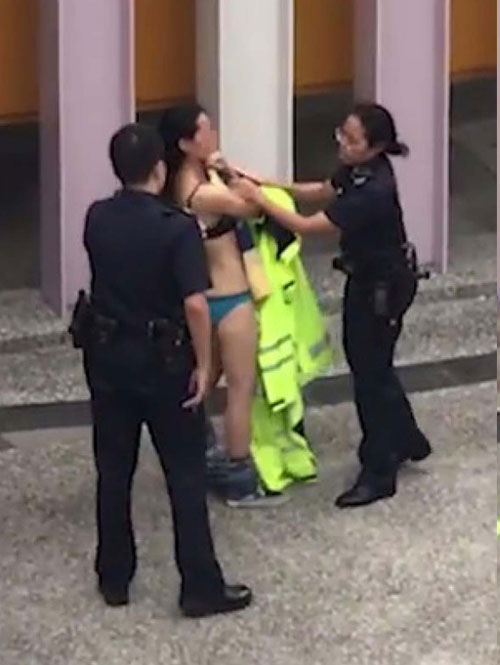 女警嘗試為女郎披上警用雨衣。（視頻截圖）