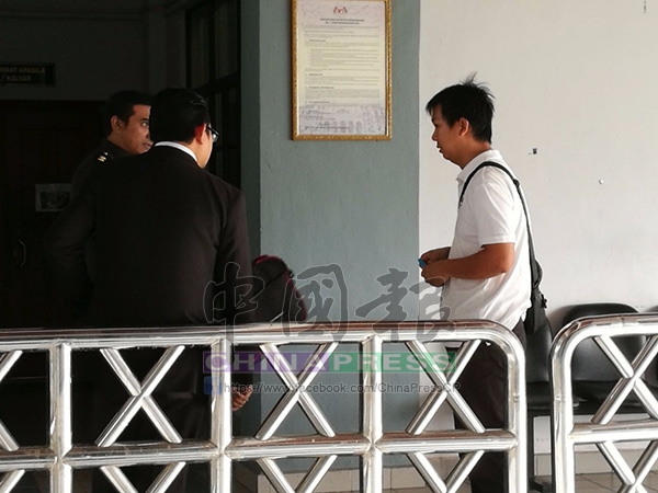 黃錦文(右)到庭外打電話,要求友人借錢繳還罰款。