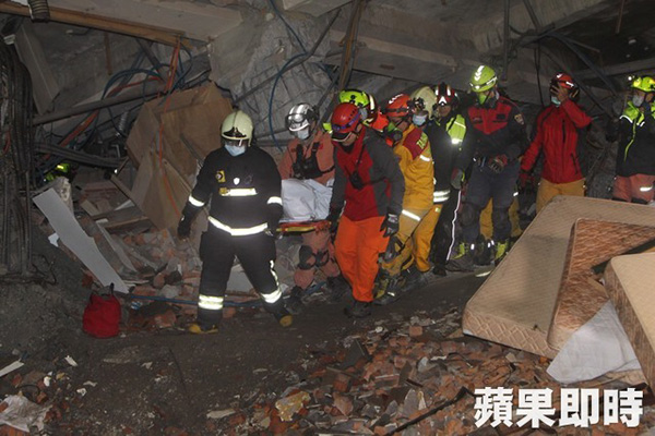 救難人員將漂亮生活旅社的罹難者抬出。∕台灣《蘋果日報》 