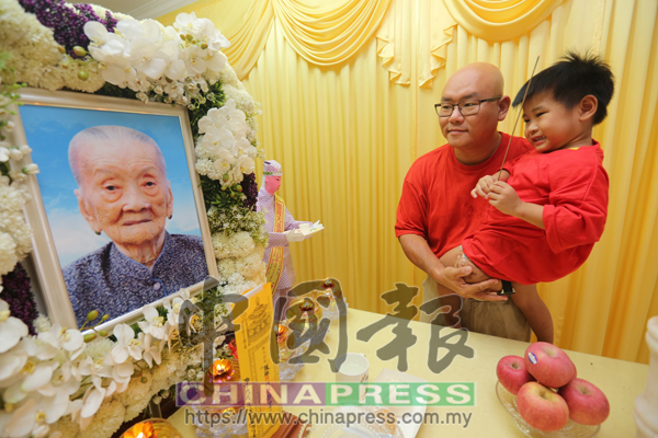 林翠蓉的孫子符傳燊抱著3歲的兒子符芳澤(曾孫男)在靈堂前上香。