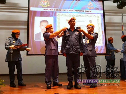 羅斯蘭(左2)及末茲布江聯合頒發榮譽勛章給柔州民防部隊成員。