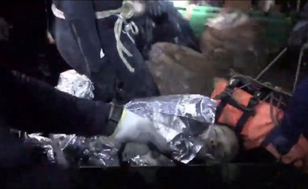 泰國當局公布的片段，顯示周二一名脫困少年，被保溫物料包裹著，他則處於昏睡中。（美聯社） 