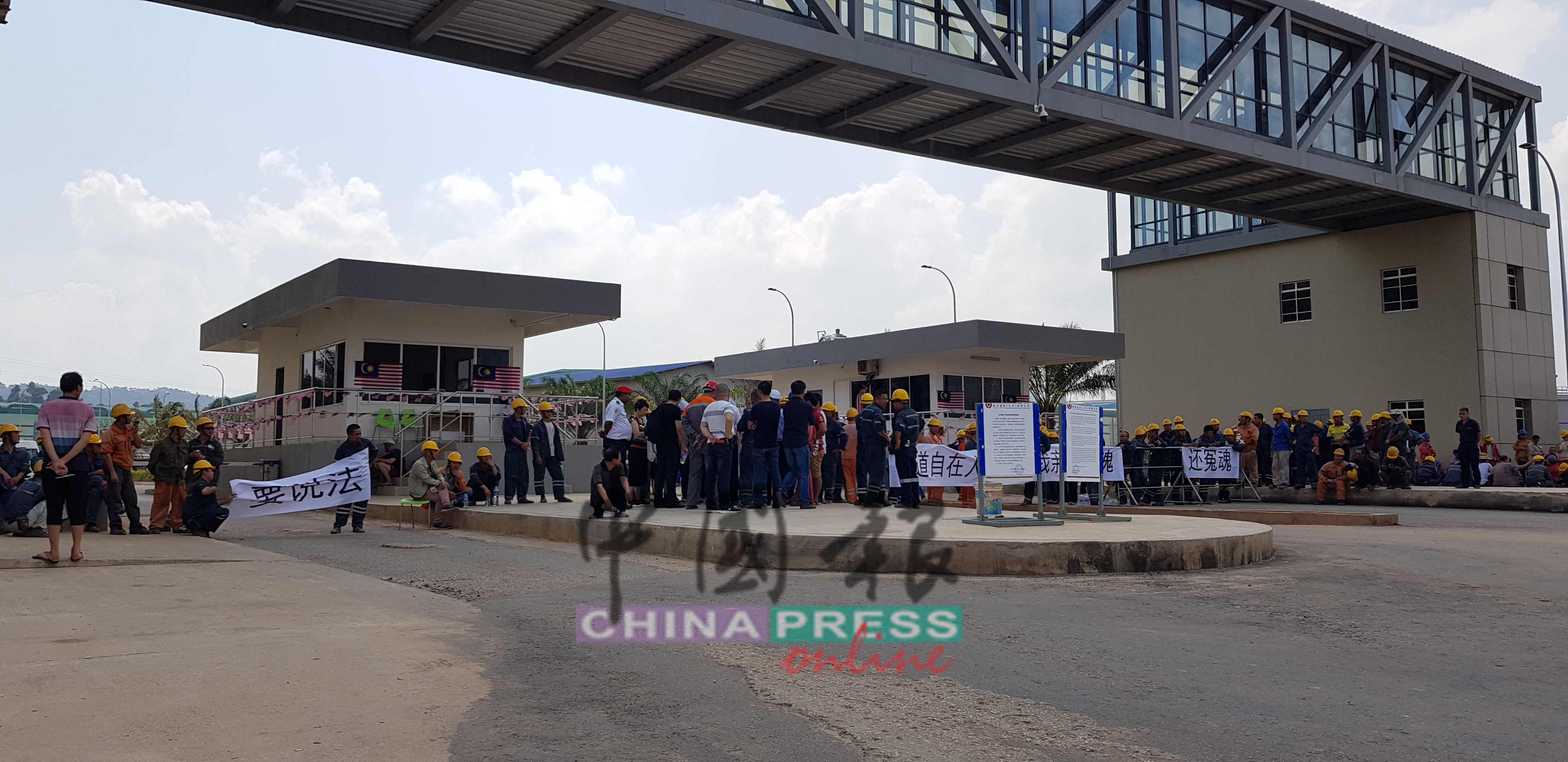 中國籍工友連同死傷者家屬在廠外拉橫幅，向公司討取公道。