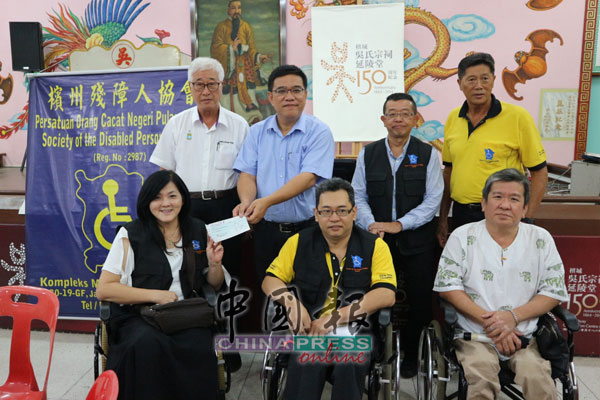 郑丽娟(前排左)在彭文宝(后排左起)见证下,从黄汉伟手中接过支票,陪同者包括黄德合(前排左2起)、李振华、叶燕泉(后排左3起)及林福基。