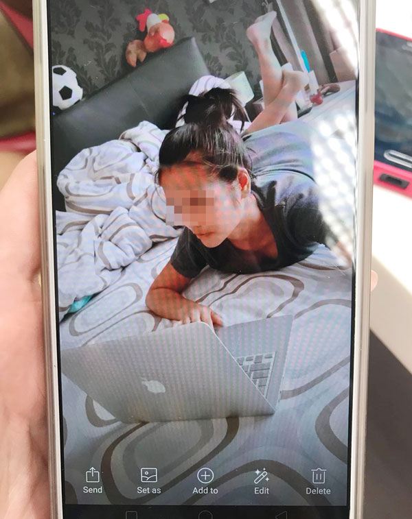 女傭拿了弟弟的筆記型電腦，趴在弟弟床上拍照。（受訪者提供）