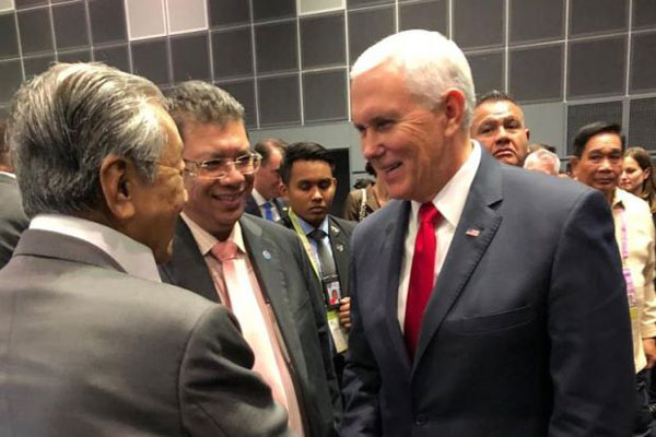  马哈迪（左）在东协峰会结束后，与美国副总统彭斯（右）展开数分钟的交流。中为外交部长赛夫丁阿都拉。（图自《星报》）