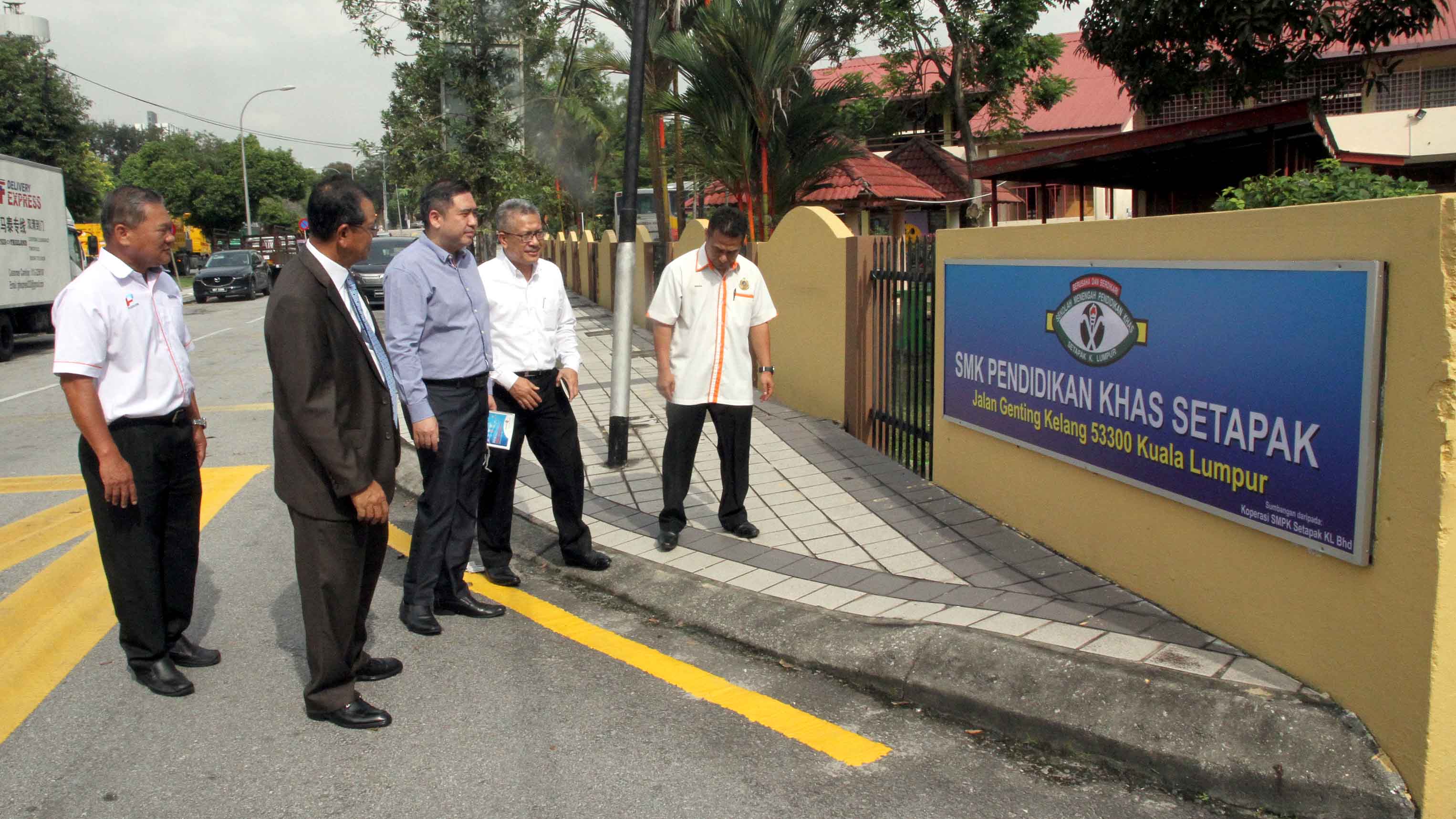 陆兆福（左2）在黄荣业（左起）、沙哈鲁丁、莫哈末苏古和依斯迈陪同下，巡视位于吉隆坡陆路交通局附近的学校。