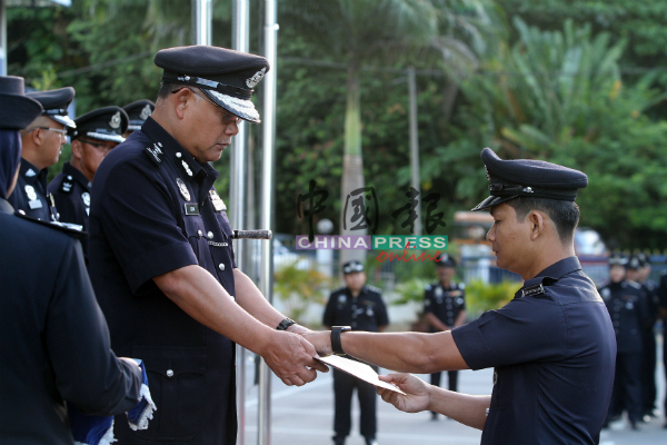 诺阿詹（左）颁发表扬状予过去表现出色的警员。