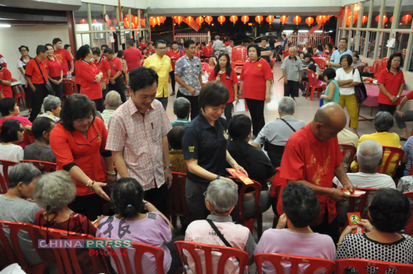 刘天财（右起）、陈丽群、谢琪清和陈云欗一起派红包给长者。