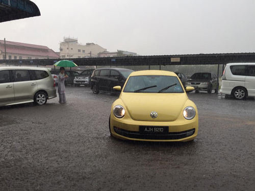 朱秀華（左）撐著傘，站在雨水中指揮交通。