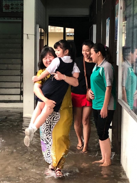 吳繡鳳抱著小女生進班，展現愛心。