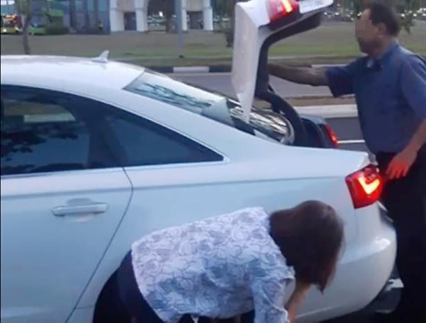 事故发生后，名车男女下车检查爱车是否被刮花。（网络视频画面） 