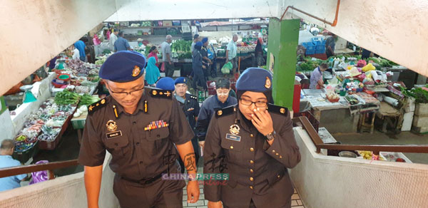 大批贸消局职员在卡立（前左）率领下，在怡保中央公市进行检查行动。