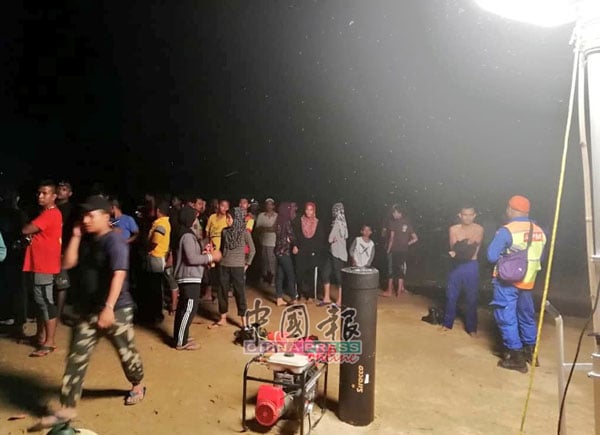 消拯員在河邊設立救援行動中心，在場還有等待消息的村民。