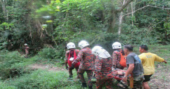 消拯员把死者的遗体抬出森林，送往瓜拉庇劳医院太平间。