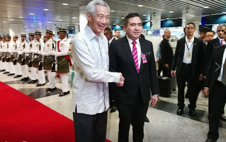 陆兆福（左2）在吉隆坡国际机场迎接李显龙（左）。（截图取自陆兆福面子书）