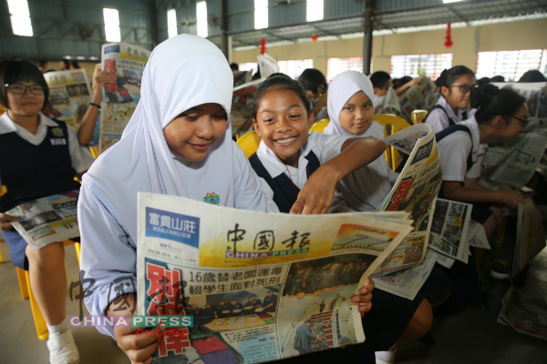 在双溪沙叻华小就读的友族学生，手持《中国报》了解新闻内容。