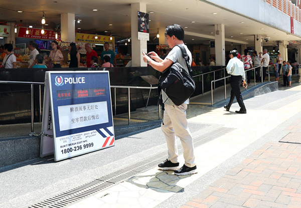 警方告示牌以趣味标语吸人眼球，有公众掏出手机拍照。