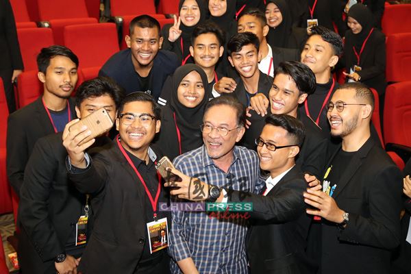 安华（前排右3）与马来西亚伊斯兰理科大学的学生一起自拍。