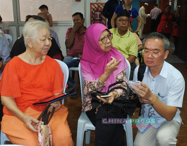 一名马来妇女向邱培栋（右）投诉。