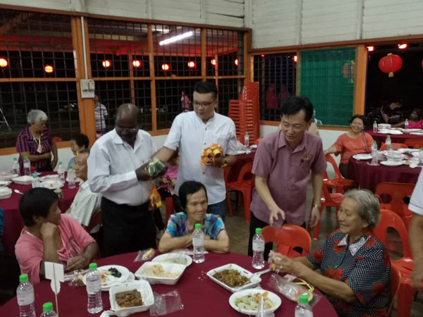P古拿（站者左起）、芙蓉市议员李汉强及谢琪清，派发礼品给年长村民。