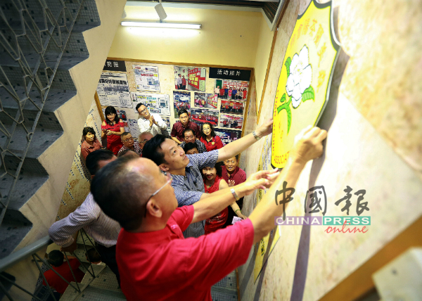 邹尚轩（左）联合谢琪清，把森茶阳会馆的模型徽章贴在“历史足迹”。