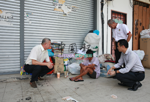 叶耀荣（左）、林佑星（右起）及林坚义向在梅岭花园商店前露宿的华裔流浪汉了解情况。
