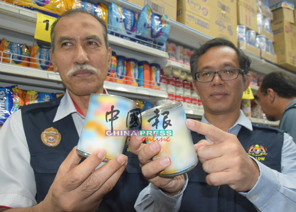 刘志良（右）与鲁希迪展示出现凹陷的炼奶罐头。