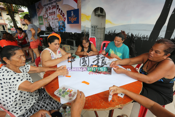 村民与民众玩传统纸牌游戏。