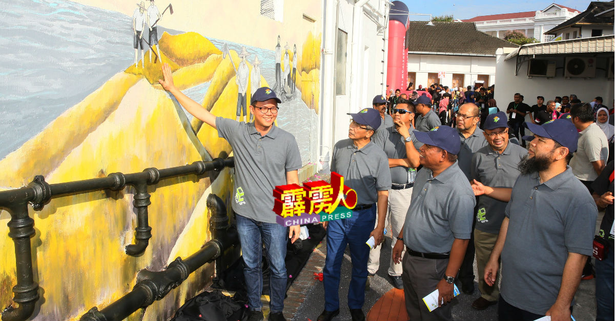陈家兴（左起）、再诺慕斯达法及扎古安，为怡保大草场后巷壁画，主持开幕仪式。