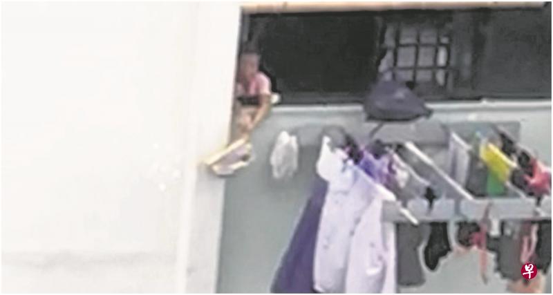 《联合晚报》读者拍到的视频显示，一名阿嫂在窗边摇晃背包，里头的纸屑和棉绒不断飞出，飘到地上。（受访者提供）