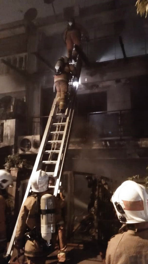 消拯员在扑灭火势后，利用云梯进入住家3楼检查。