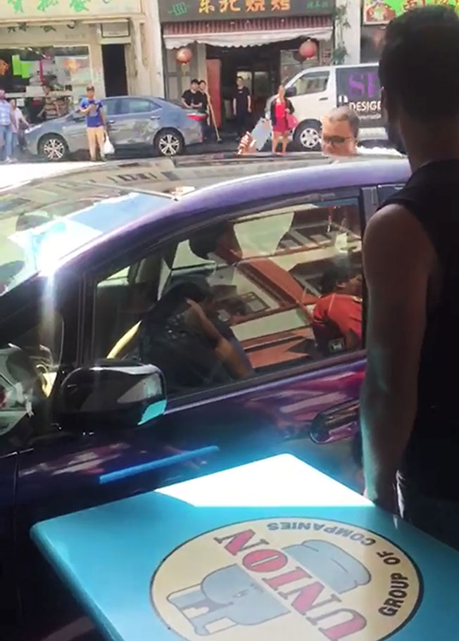 古玛拍摄的视频显示，女车主因手不断抽搐，无法打开车门。（受访者提供）