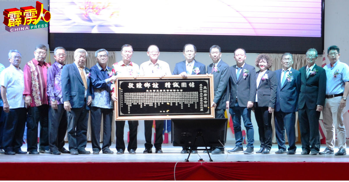陈治年（左6）代表赠送牌匾给曼绒广东会馆代表冯国强（右6起）及陈利进等理事接领。