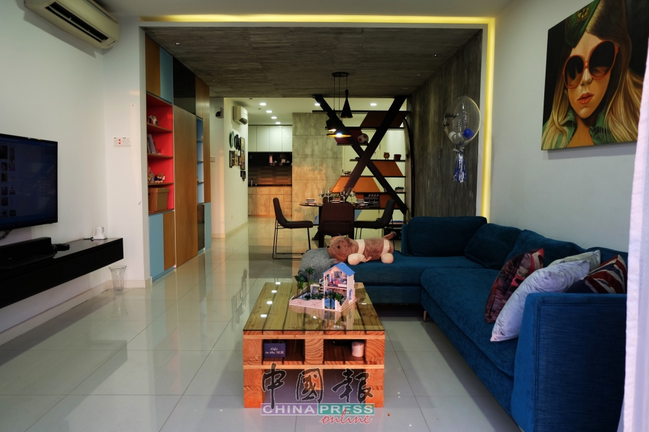 客厅以高级蓝布艺沙发，配搭木质短桌，随性写意；采用挂壁式电视，并且具有伸缩性设计，可依屋主需求而随意移动。