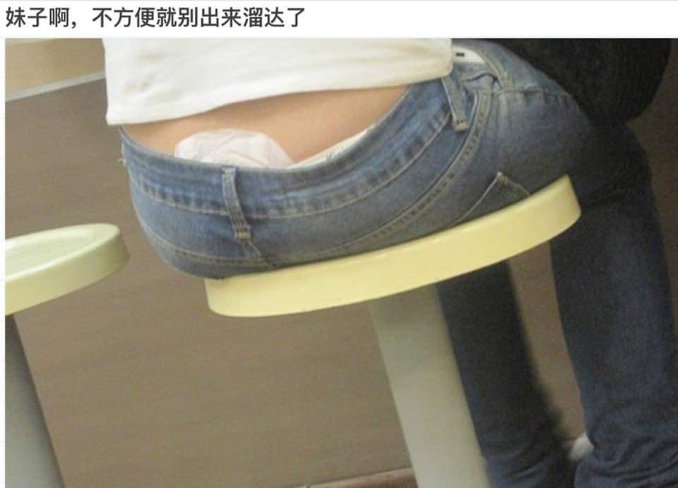 一名穿著低腰牛仔褲的女士不小心露出了一小截的衛生巾。