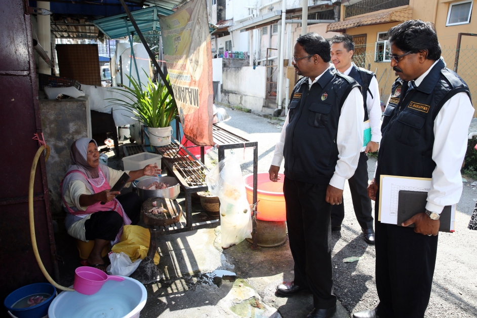 威拉班（右3）及执法官员检查时，发现餐馆员工在后巷沟渠旁准备食材。