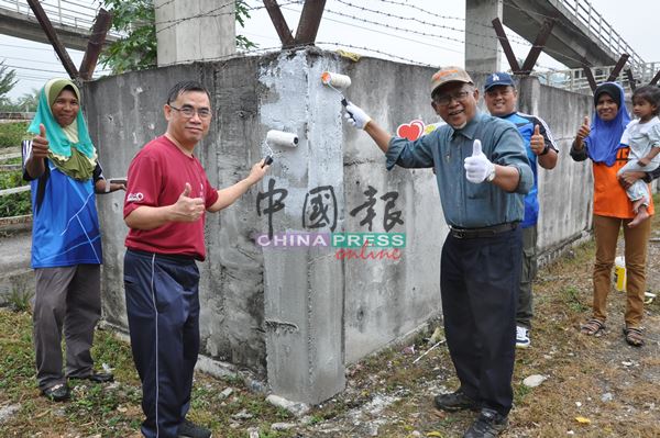 王祖祥牧师（左2）及依斯迈阿末为清真寺前的摩哆天桥围墙髹上新漆。
