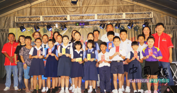 育才华小24名学生领取学业优良奖励金，与嘉宾分享喜悦。