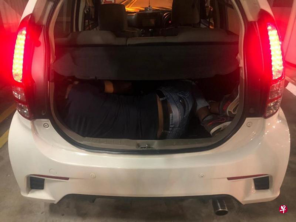 执法人员在兀兰关卡截查一辆马来西亚注册的轿车时，发现一名男子藏在后备箱内。（新加坡移民与关卡局提供） 