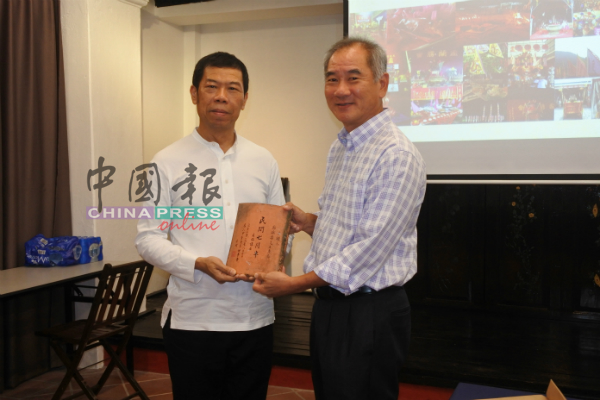 青云亭副主席张锦良（右起）赠送纪念品给郑锦华。