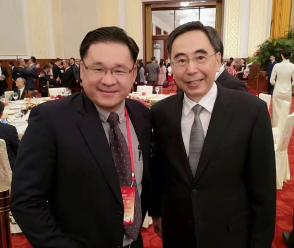 颜天禄（左起）与朱小丹在新中国成立70周年招待会上会面交流。