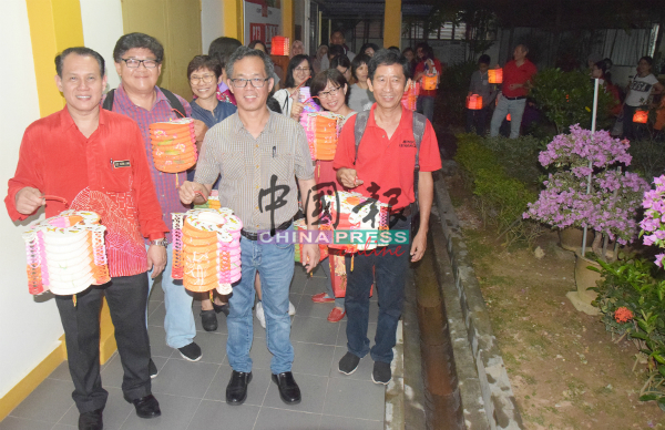 李顺伟（前排左起）、刘志良、丘力鸣率领家长、学生提灯笼游行。