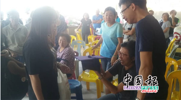 甘佳盈(左)把毕业四方帽,交到李金燕(中)手中后,李金燕看着毕业四方帽,失声痛哭,令人心酸。