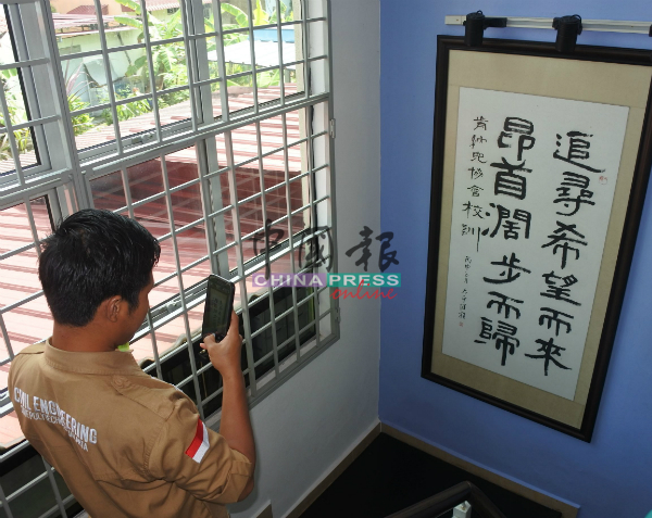 印尼学生虽不谙中文，却对肯纳儿协会由继程法师写的校训书法深感兴趣。