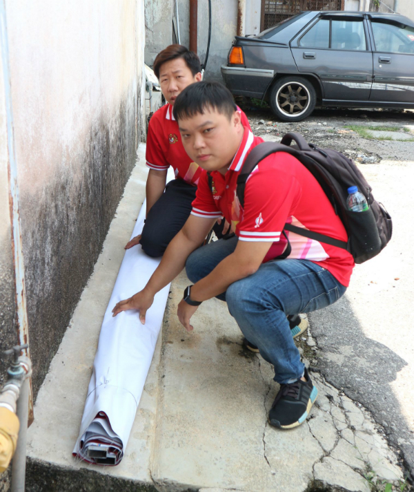 朱智威（右起）和刘伟漩检查被丢在巷子的条幅与横幅，幸没有损坏。