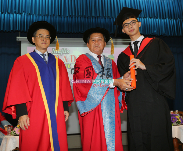 颜贞强（左2）在吴大鹏（左）陪同下，颁发毕业证书给毕业生。