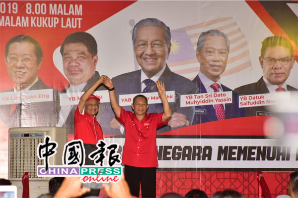 马哈迪（左起）拉起卡敏的手，呼吁选民支持他。
