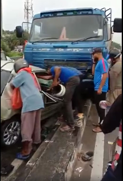 路过的民众尝试救出受困的轿车司机。